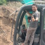 Alat berat sedang menggali untuk pembuatan drainase mengatasi banjir